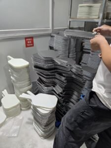 Stacked honeycomb core sheets and composite face materials on the layup table at the Gloperti paddle factory