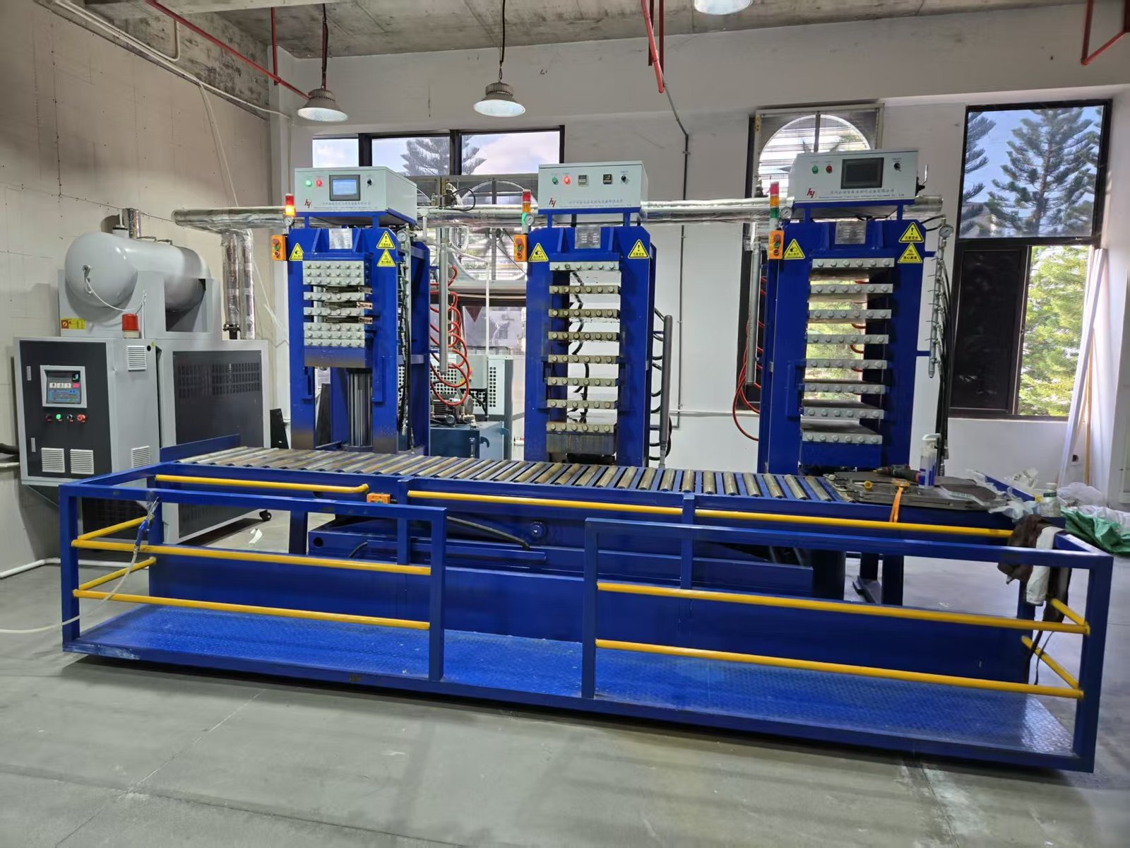 Thermoforming press equipment used in composite pickleball paddle manufacturing.