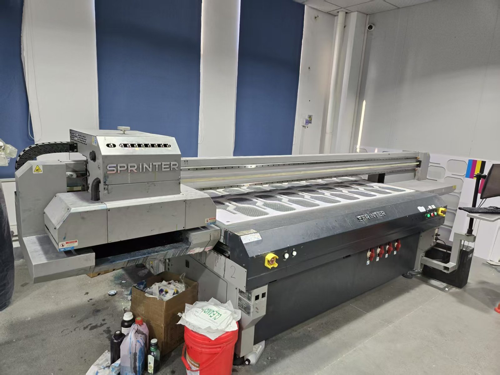 Industrial UV printing machine producing custom graphics on pickleball paddle surfaces.